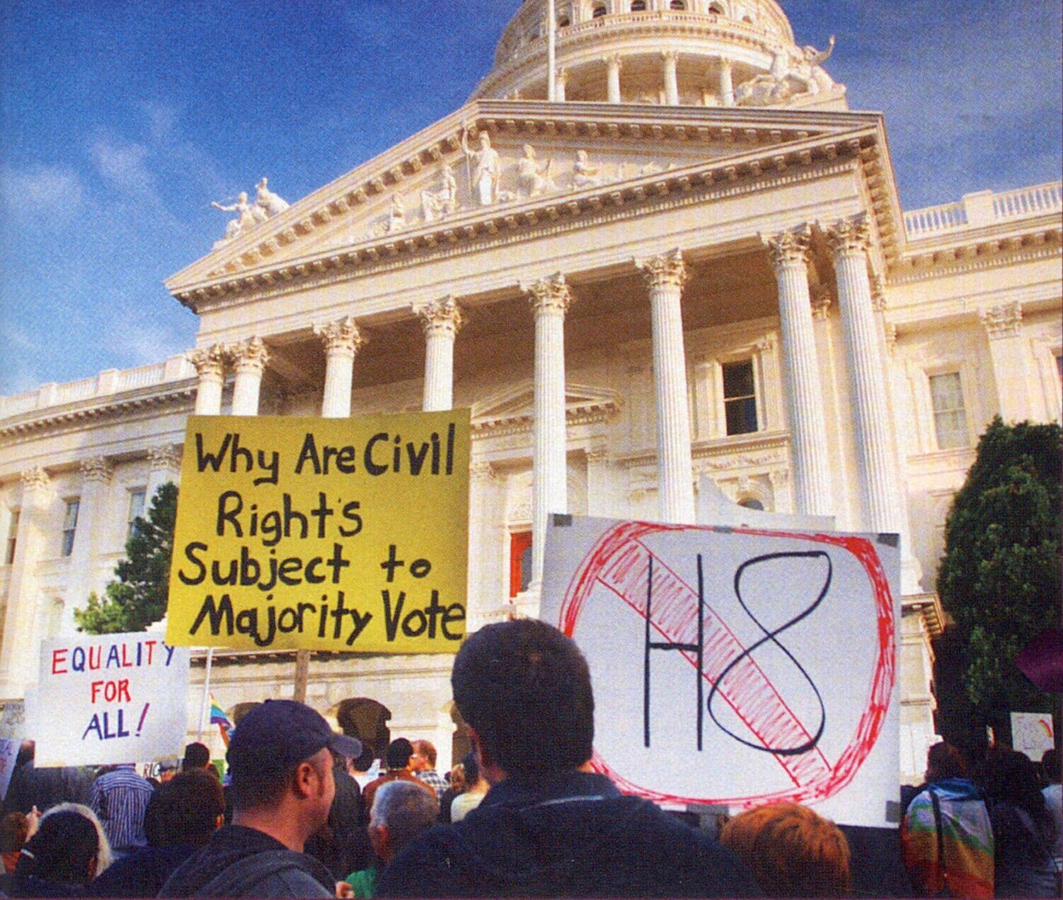 People protesting outside of the Supreme Court for Prop 8, holding protest signs that say "no hate" and "why are civil rights subject to majority vote".
