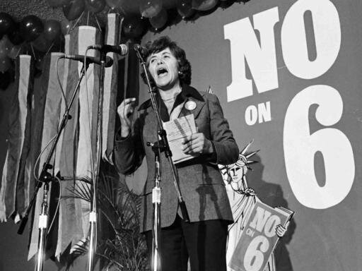 Black and white documentary film still from Sally! Featuring Sally Gearhart speaking at the podium.
