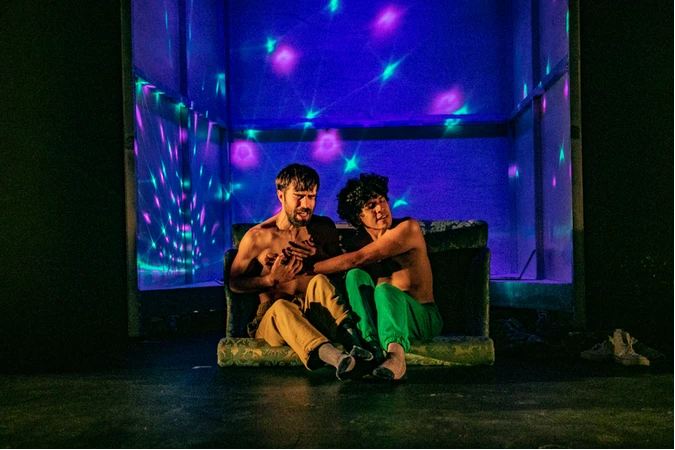 Fotograf&iacute;a de la representaci&oacute;n en la que se ve a los dos actores sentados sobre un viejo sof&aacute;.