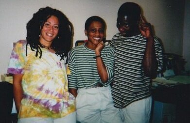 Three smiling brown skinned performers face the camera in a candid backstage pic from 1993