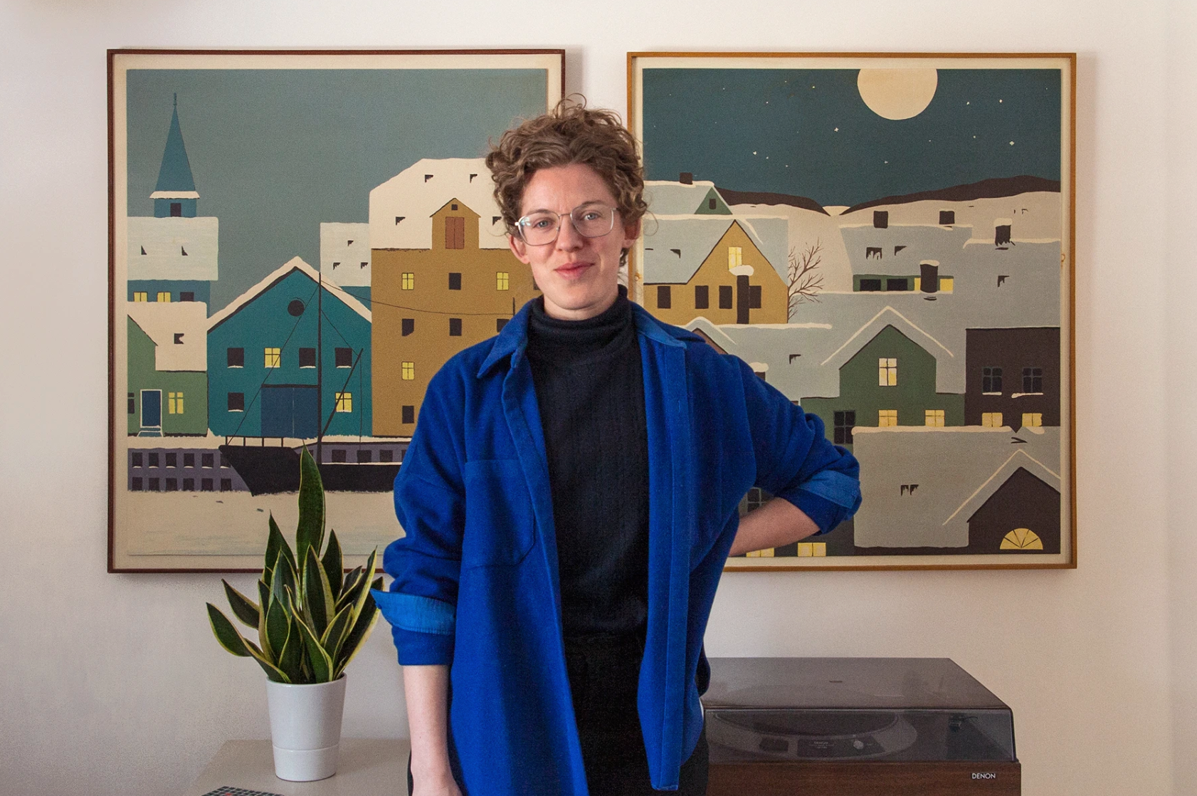 Ruth Skinner stands in front of two paintings