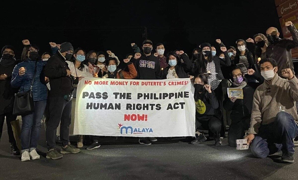 Image of 8 people holding up a banner that says Malaya South Bay and several papers that say "never again to martial law"