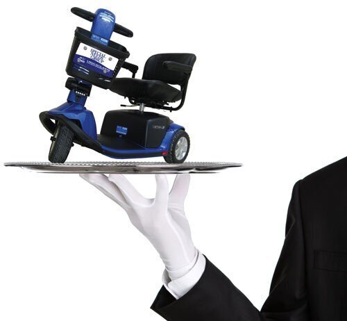 Hand with white glove holding a silver plate with mobility scooter on top