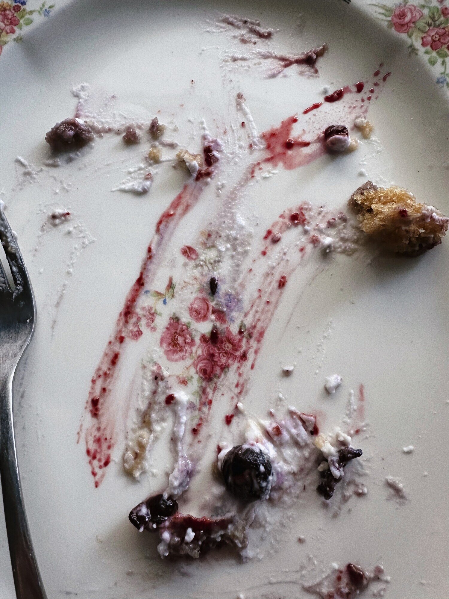 An overhead shot shows blueberry compote, cake crumbs, and coconut cream smears on a plate.